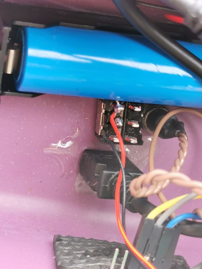 a photo of the epoxied in microUSB connector, along with the backlight control switch, the 'put it into flash mode' switch, and the 18650 cell in its holder